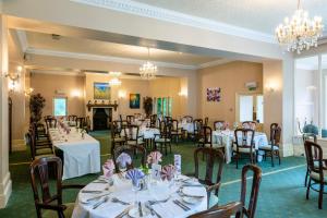 a banquet room with tables and chairs and a fireplace at Penmorvah Manor Hotel in Falmouth