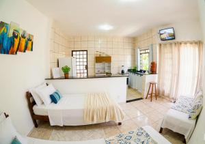 a living room with a bed and a kitchen at Casa Inteira Com Total Privacidade e Quintal in Pará de Minas