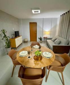 a living room with a wooden table and chairs at Flat Aconchego no Setor Oeste a 50m do Lago das Rosas, apto novo in Goiânia