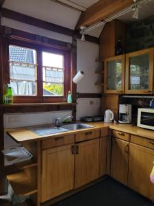 a kitchen with wooden cabinets and a sink and a microwave at Alte Schmiede in Halver