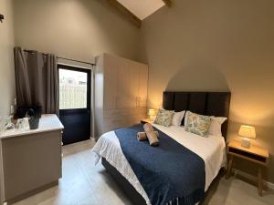 a bedroom with a large bed with a blue blanket at Autumn's Rest in George