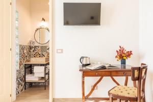 a room with a desk and a table with a television at Villa Fontis Rapolano in Rapolano Terme