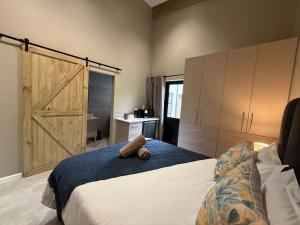 a bedroom with a large bed with a sliding barn door at Autumn's Rest in George +8 photos