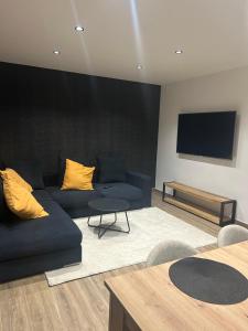 a living room with a blue couch and a flat screen tv at L'Escale Gare Châteaucreux avec Garage in Saint-Étienne