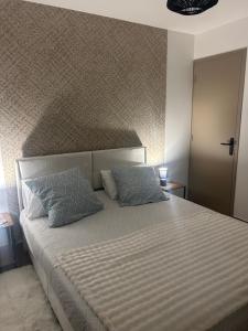a bedroom with a large bed with two pillows at L'Escale Gare Châteaucreux avec Garage in Saint-Étienne