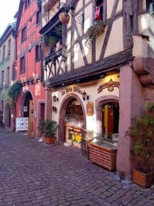 a street with a store on the side of a building at Le Bredele in Riquewihr