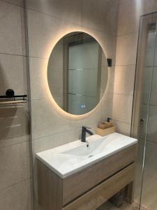 a bathroom with a sink and a mirror at L'Escale Gare Châteaucreux avec Garage in Saint-Étienne +11 photos