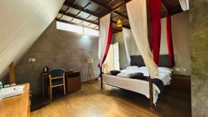 a bedroom with a canopy bed and a desk at The Western Inn in Mananthavady