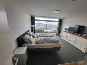 a bedroom with a bed and a flat screen tv at Studio Residentie Astrid Bredene in Bredene