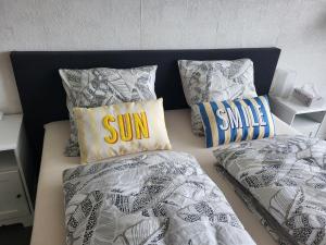 two beds with pillows with the words sun on them at Studio Residentie Astrid Bredene in Bredene
