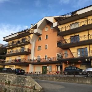 un gran edificio naranja con coches estacionados frente a él en B&B il Tulipano, en Rogliano