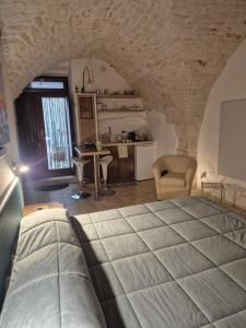 a bedroom with a large bed and a kitchen at La Volta del Conte-Holiday Home Centro Storico in Cisternino