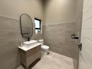 a bathroom with a sink and a mirror and a toilet at Autumn's Rest in George