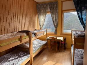 a room with bunk beds and a table and a window at Hellesylt Hostel in Hellesylt