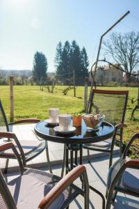 a table and chairs with cups and saucers on a patio at Kuća za odmor Franca in Ozalj