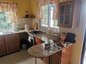 a kitchen with a granite counter top and a sink at Karibik Ocean view Guesthouse Trinidad in Las Cuevas