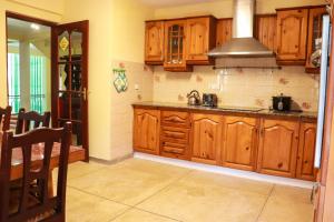 a kitchen with wooden cabinets and a sink at Kandy downtown villa Monza in Bahirawakanda