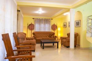 a living room with couches and chairs and a table at Kandy downtown villa Monza in Bahirawakanda