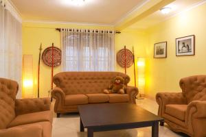 a teddy bear sitting on a couch in a living room at Kandy downtown villa Monza in Bahirawakanda +1 photo