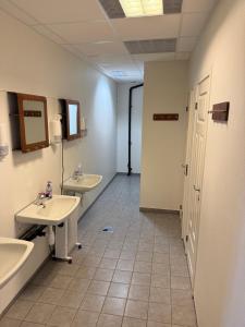 a bathroom with two sinks and two mirrors and a doorway at Hellesylt Hostel in Hellesylt