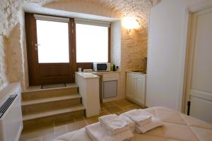 a small kitchen with a bed and a window at Arcobaleno in Locorotondo