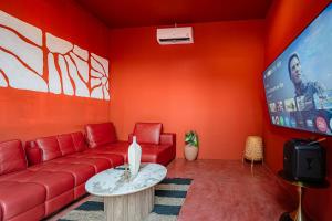 a living room with a red couch and a flat screen tv at Afro Pool Villa Bangsean 01 in Ban Puk (2)