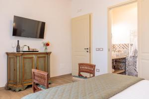 a bedroom with a bed and two chairs and a television at Villa Fontis Rapolano in Rapolano Terme