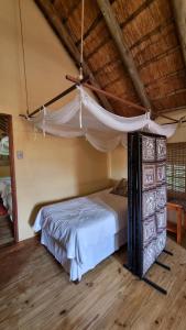 a bedroom with a bed with a mosquito net at Namagong in Marloth Park +57 photos