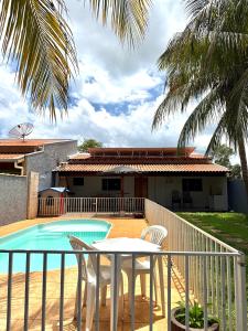 a balcony with a table and chairs next to a swimming pool at Rancho Camiotto in Rubinéia