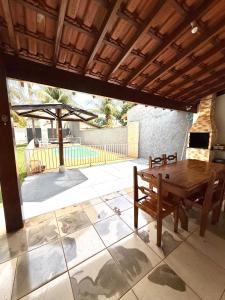 a wooden table and bench on a patio at Rancho Camiotto in Rubinéia