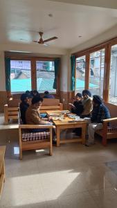 a group of people sitting at tables in a room at Himalayan bite pulga in Kalgha