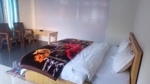 a bedroom with a bed with a blanket on it at Himalayan bite pulga in Kalgha
