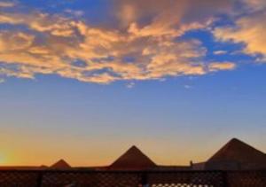a view of the pyramids of a building at sunset at Nefertari Pyramids View Inn in Cairo