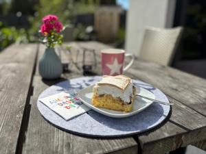 a piece of cake on a plate with a cup of coffee at Inselbutze Fehmarn in Fehmarn