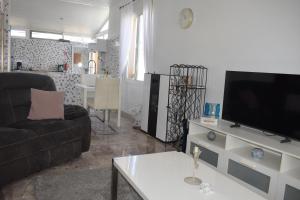 a living room with a couch and a flat screen tv at Casa de la Serenidad in Mazarrón