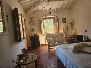 a bedroom with a bed and a chair and a window at Dimora Rosé in Crespina