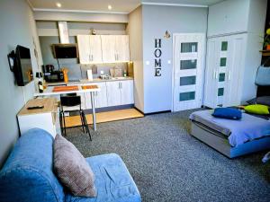 a living room with a couch and a kitchen at Apartament Na Reymonta in Starogard Gdański