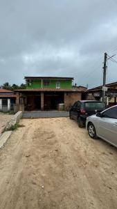 a house with two cars parked in front of it at Pousada Raízzes in Amontada