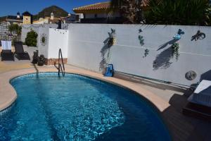 a swimming pool with a wall with a painting on it at Casa de la Serenidad in Mazarrón