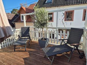 three chairs on a deck with a white fence at Rebenhaus St Martin in Sankt Martin