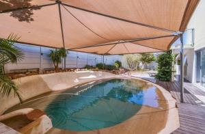a swimming pool with an umbrella in a yard at Villa Oceanic Escape in Hout Bay