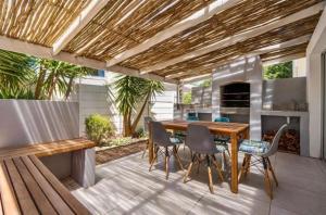 a patio with a wooden table and chairs at Villa Oceanic Escape in Hout Bay