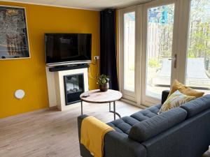 a living room with a couch and a tv at Studio Watertoren in Goes