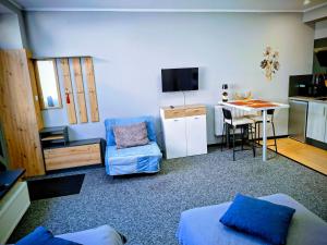 a small living room with a table and a kitchen at Apartament Na Reymonta in Starogard Gdański