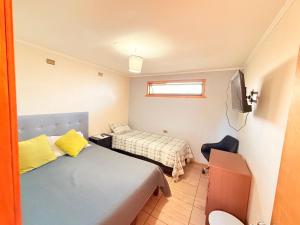 a small bedroom with a bed and a television at Hospedaje Amore per il lago in Villarrica