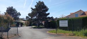 a gate in a driveway with a sign on it at Charmante Maison Bord de Mer avec Piscine et Tennis 5-P in Saint-Vincent-sur-Jard