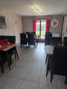 a dining room with tables and chairs and red curtains at Jardin Floral in Marquise +9 photos
