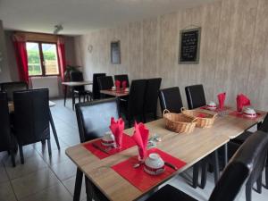 a dining room with a wooden table with red napkins at Jardin Floral in Marquise