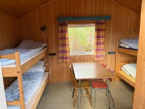 a room with two bunk beds and a table and a window at Hellesylt Hostel in Hellesylt +46 photos