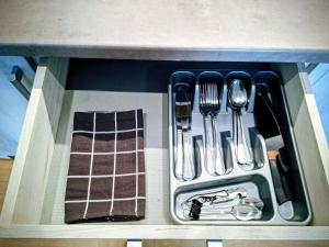 a drawer with silver utensils in a sink at Apartament Na Reymonta in Starogard Gdański +4 photos